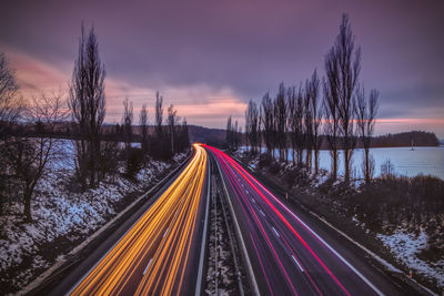 High angle view of light trails on road against sky during sunset