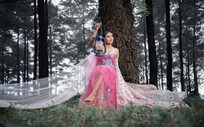 Full length of woman standing in forest