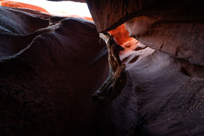 Midsection of man on rock formation in cave