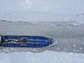 Snow covered land by sea during winter