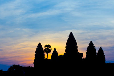 Low angle view of silhouette trees against sky at sunset