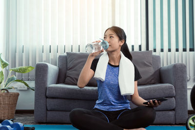 Young woman sitting on sofa at home