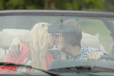 Young couple kissing in car