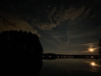 Scenic view of silhouette trees against sky at night