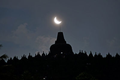 Low angle view of silhouette temple against sky