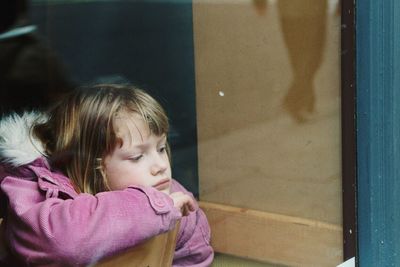 Bored girl looking through window