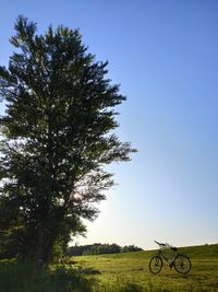 Bicycle on field against clear sky