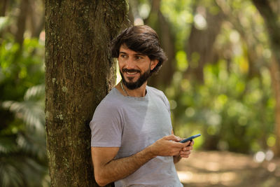 Young man at park on a beautiful sunny day with mobile phone.  working  leisure. green and nature 