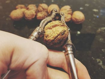 Cropped hand of person cutting nut - food