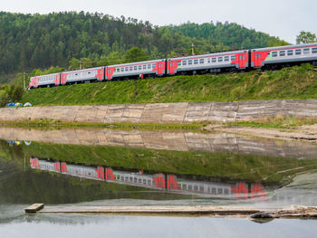 Train by railroad tracks by river