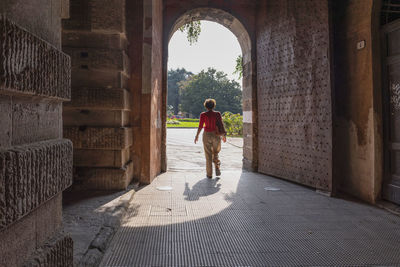 Rear view of woman walking in tunnel