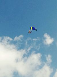 Low angle view of parachute against blue sky