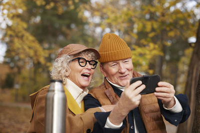 Senior couple taking selfie in park