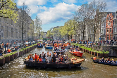 Locals in orange celebrating kings day on the canals in amsterdam the netherlands