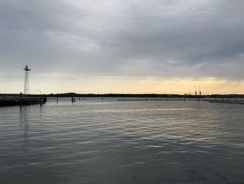 Bridge over river against sky at sunset