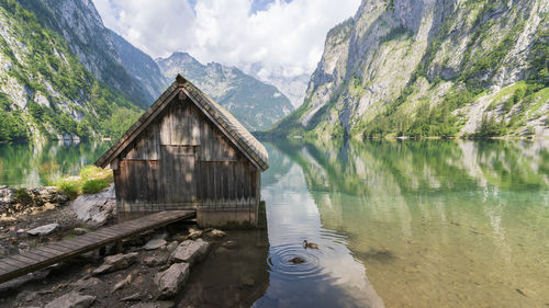 Old wooden boathouse on a pristine alpine lake surrounded by mountains, obersee, germany