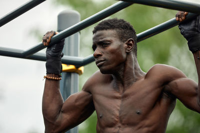 Low angle view of shirtless man standing outdoors