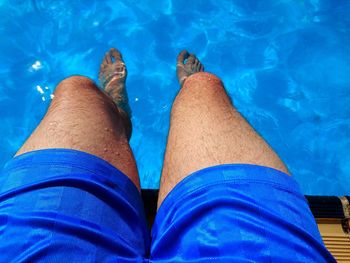 Low section of man legs in swimming pool