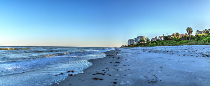 Scenic view of beach against clear blue sky