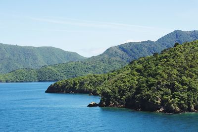 Scenic view of sea and mountains against clear sky