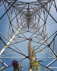 Low angle view of electricity pylon against blue sky