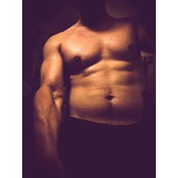 Midsection of shirtless man standing