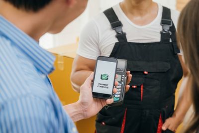 Midsection of man using mobile phone