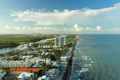 High angle view of city by sea against sky