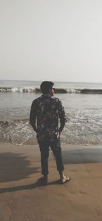 Rear view of man standing on beach