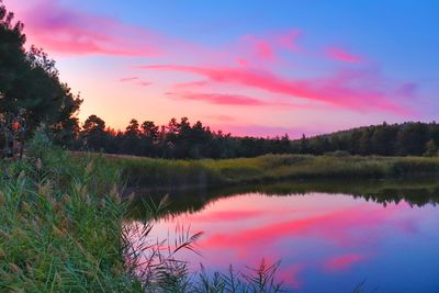 Scenic view of lake against sky at sunset