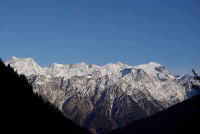 Scenic view of snowcapped mountains against clear blue sky