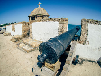 Canon in fort against clear sky on sunny day