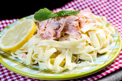 Close-up of pasta in plate on tablecloth