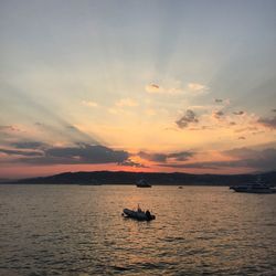 Boat sailing in sea at sunset