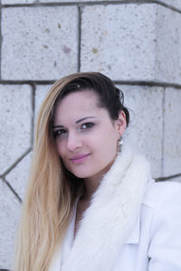 Portrait of smiling woman against wall