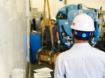 Rear view of young man working in factory