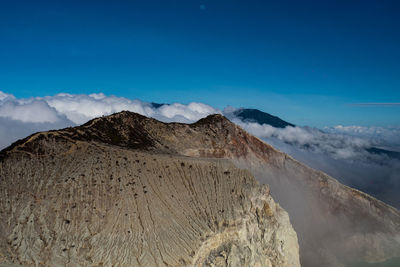 Scenic view of mountains against blue sky