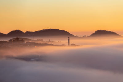 Scenic view of silhouette mountains against orange sky