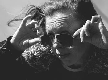 Woman holding sunglasses while looking away