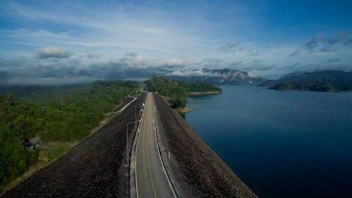 Scenic view of road by mountains against sky