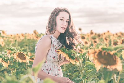 Young woman wearing hat standing on field