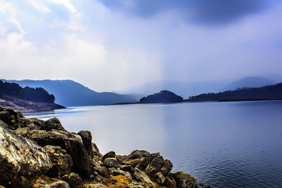 Scenic view of sea and mountains against sky