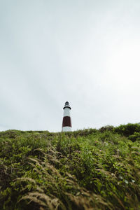 Lighthouse on field against clear sky