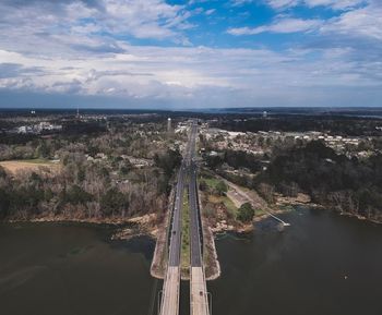 Aerial view of river amidst cityscape against sky