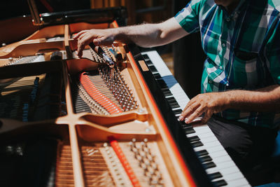 Midsection of man playing piano