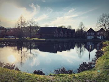 Scenic view of lake by buildings against sky
