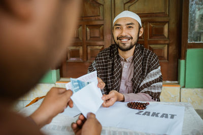 Young man doing charitable donation at mosque