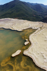 High angle view of lake by mountain against sky