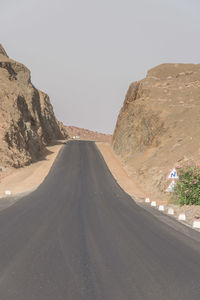 Road amidst desert against clear sky