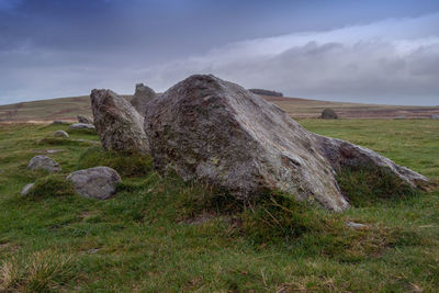 Rocks on field against sky